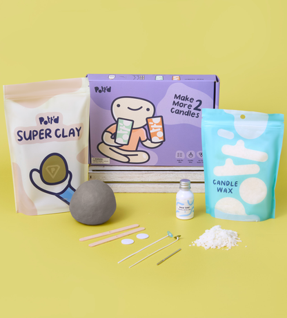 Candle making kit with purple box and blue wax bag on a yellow background, includes grey clay and tools.
