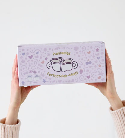 Hand holding green Monstera leaf-shaped ceramic dish with silver rings, on a light wooden surface background.