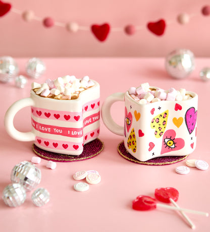 Colorful air-dry clay cactus ring holders with playful designs, set on a wooden surface alongside a decorative mug.