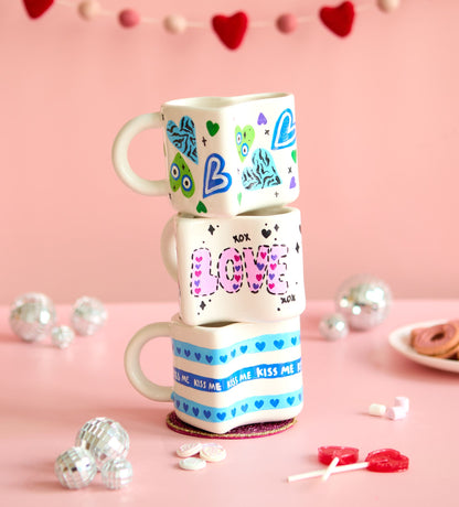 Ceramic cactus and panda figurines elegantly displayed in a golden wire frame on a wooden base by a window.