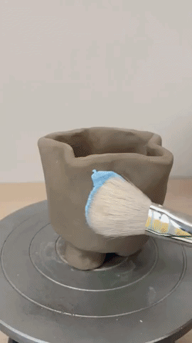 GIF of someone painting a candle holder made from Pott'd clay and then pouring wax and lighting the candle