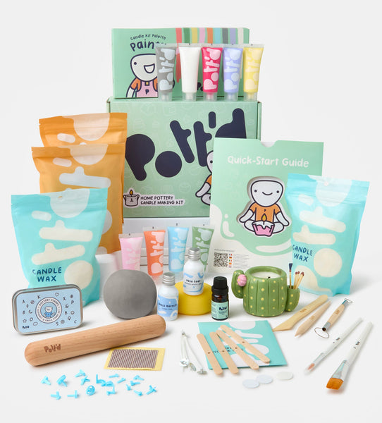 Home pottery candle making kit and paintable mug set in pastel-colored boxes on a soft pink background.