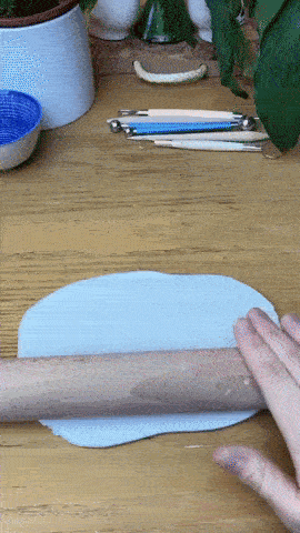 GIF of someone cutting and shaping clay into a crescent moon